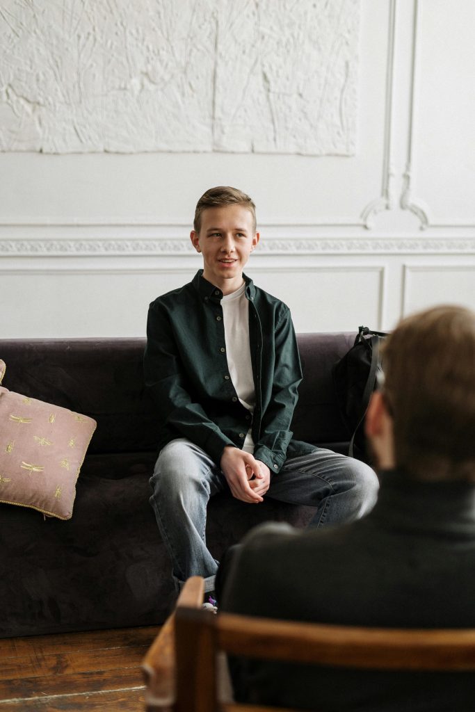 A therapist and patient engaged in a counseling session in a stylish loft setting.